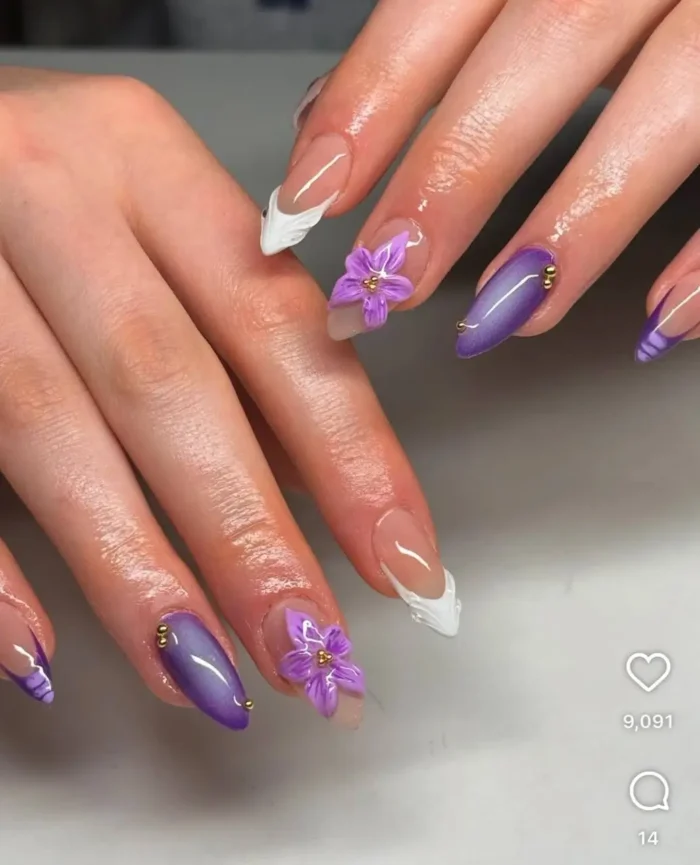 Almond nails with a velvet orchid and pearls purple nail design, showcasing 3D flowers, satin purple, and gold bead accents with French tips.
