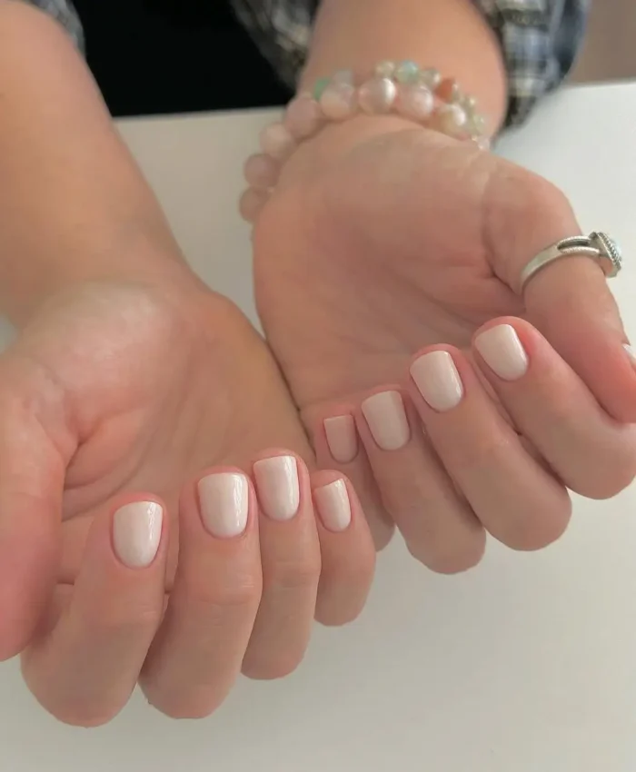 Perfectly manicured short, square nails featuring a flawless, creamy nude polish for a clean and elegant look.