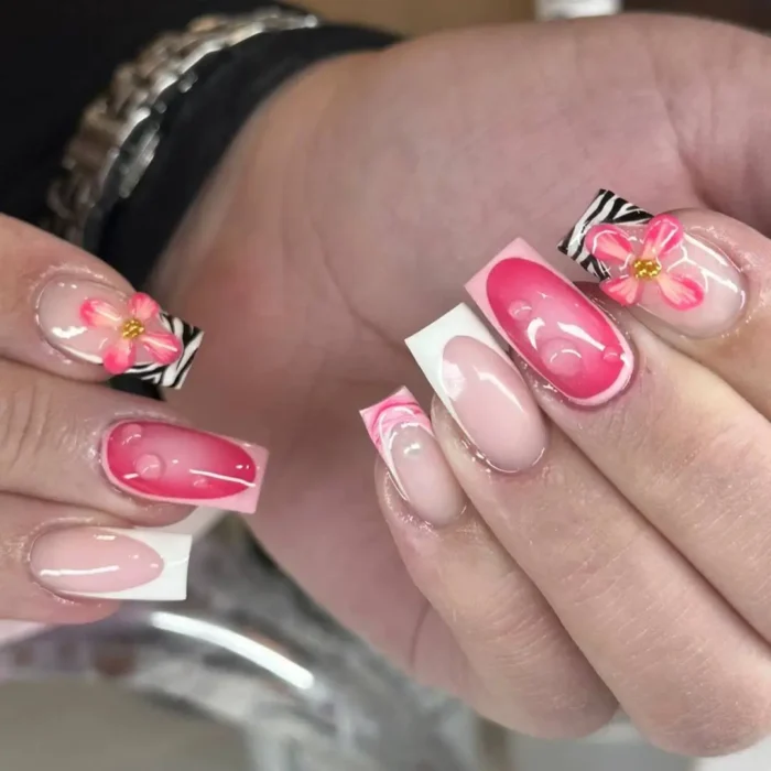 Square nails with leopard print French tips, accented with a vibrant 3D fuchsia flower and gold beads.