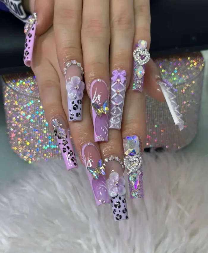 Ultra-long lavender overload freestyle nail design, with cheetah print, 3D florals, heart crystals, and corset details.