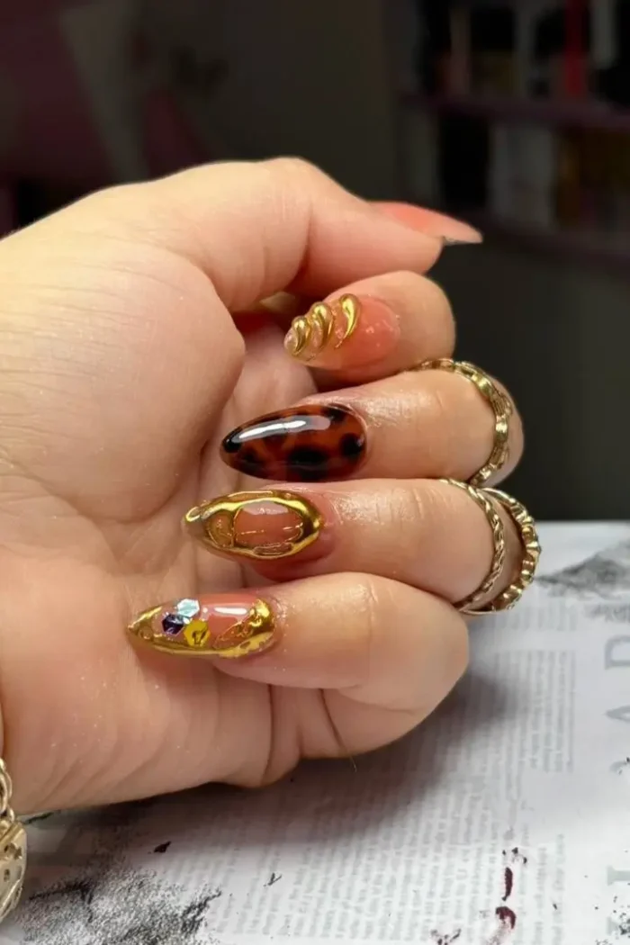 A chic tortoiseshell nail art design on medium almond-shaped nails with a glossy finish.