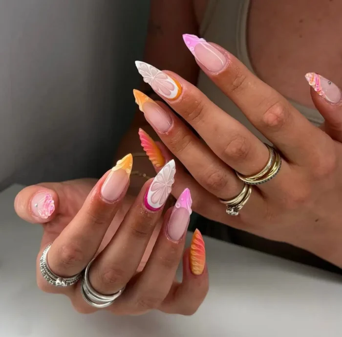 Modern summer nail art design on long almond nails featuring colorful abstract floral French tips in orange, pink, and white.