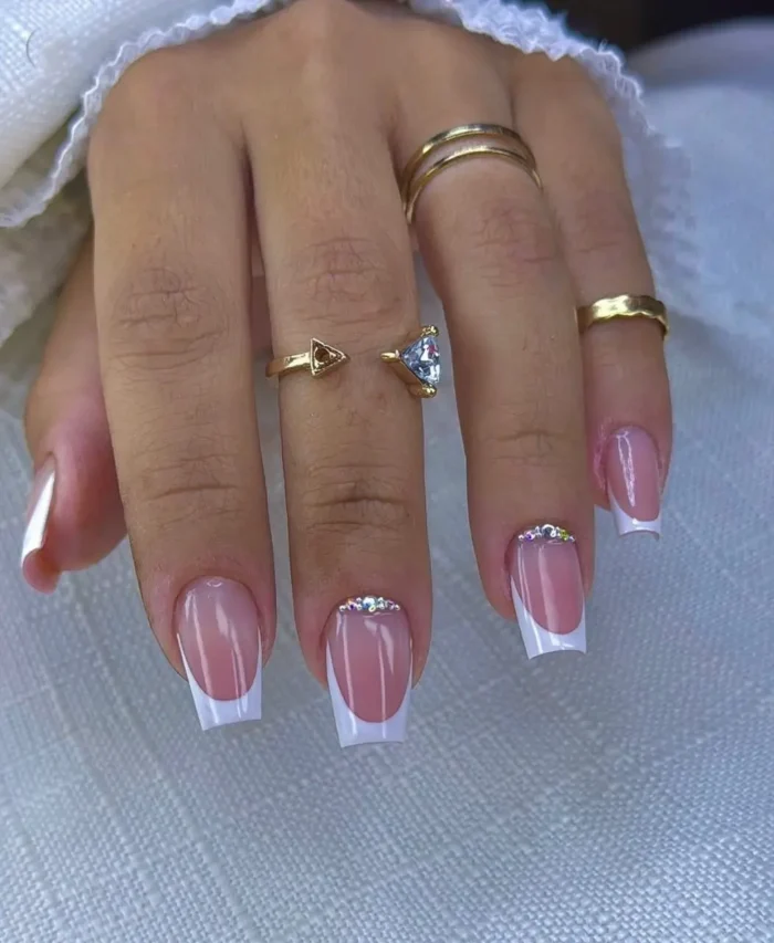Short to medium square nails showcasing a classic white French manicure, beautifully enhanced with a fine line of clear rhinestones along the smile curve.