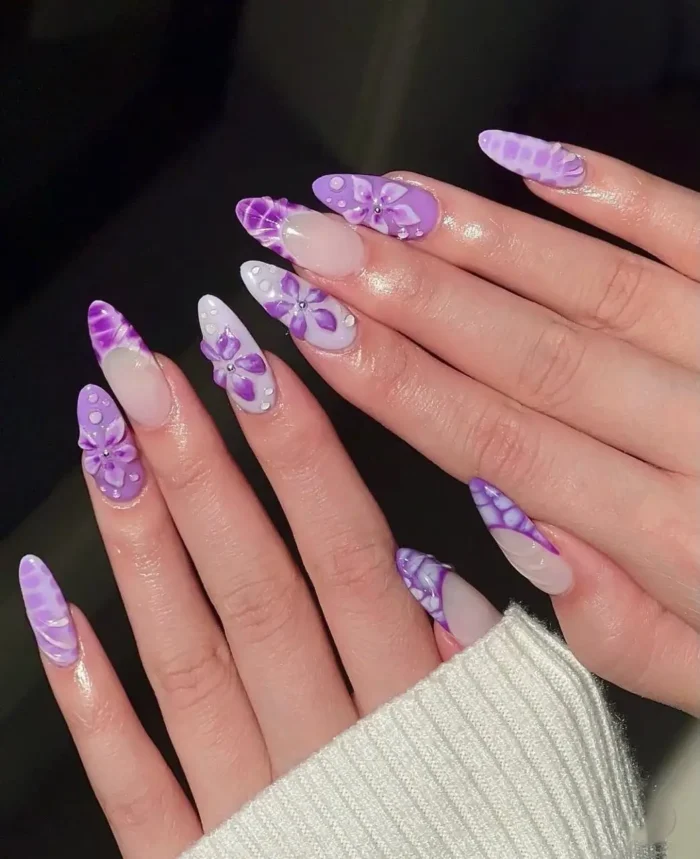 Almond nails with an orchid rain purple nail design, featuring 3D layered purple flowers and glossy water droplet effects.
