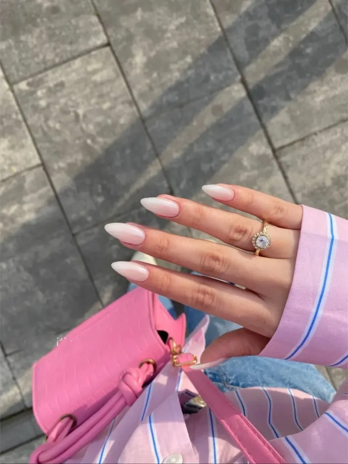 Cute simple gel manicure with a chic pearlescent glazed white finish on medium pointed almond nails.