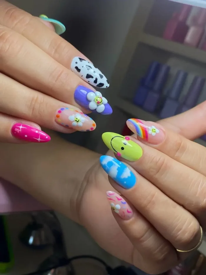 A colorful kidcore mix-and-match nail art design with smiley faces, checkerboard print, a yin-yang symbol, and flowers.