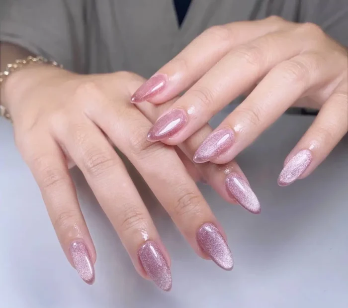 Cute simple gel manicure with a glamorous rose gold pink cat-eye shimmer effect on medium-long almond nails.