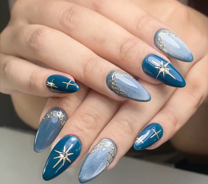 Almond nails featuring glossy teal with gold starbursts, and magnetic grey-blue polish with ornate gold detailing near the cuticles.