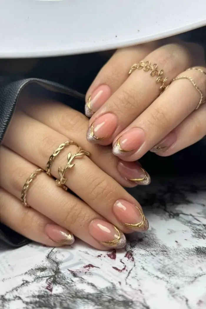 A minimalist micro French manicure with a sheer nude base and a very thin, metallic gold tip on short square nails.