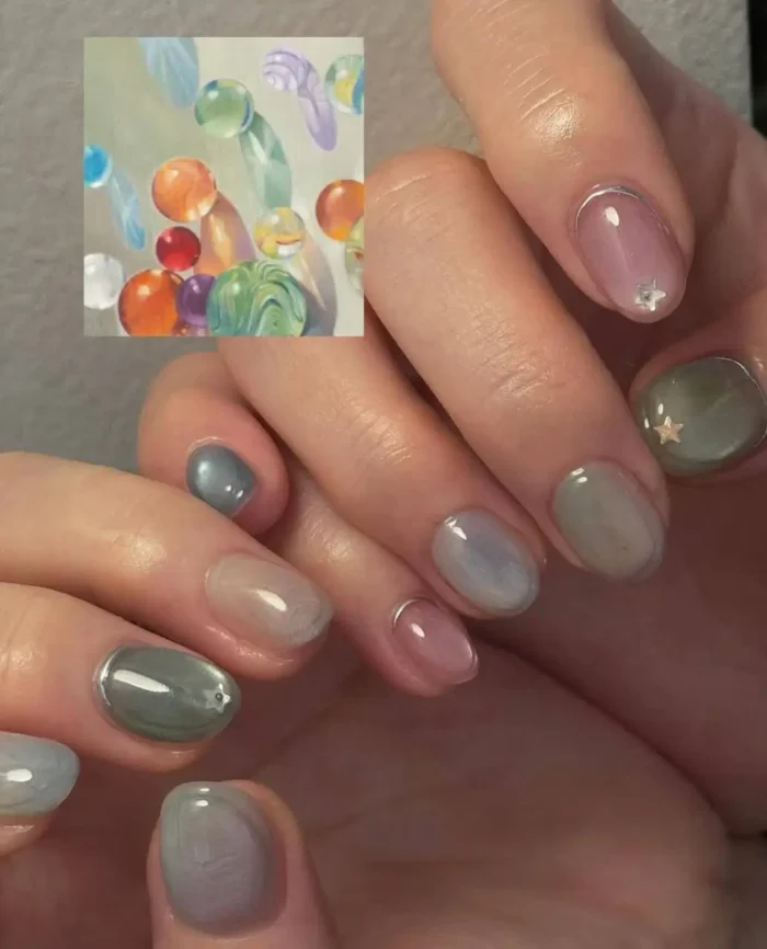 A sophisticated nail art design inspired by natural stones, featuring marbled earthy tones, a subtle shimmer, and metallic accents.
