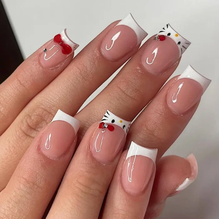 Medium square-shaped nails with a classic white French manicure, charmingly decorated with iconic cartoon character face art and 3D red bow embellishments.