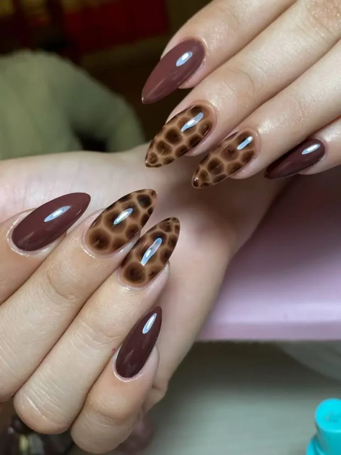 A modern fall manicure on short square nails with mustard yellow, burnt orange, and a leopard print accent nail.
