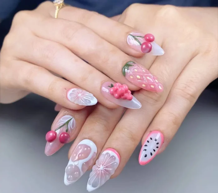 Long stiletto nails with a fruit theme featuring various 3D sculpted elements like cherries, strawberries, citrus slices, dragon fruit, and berries.