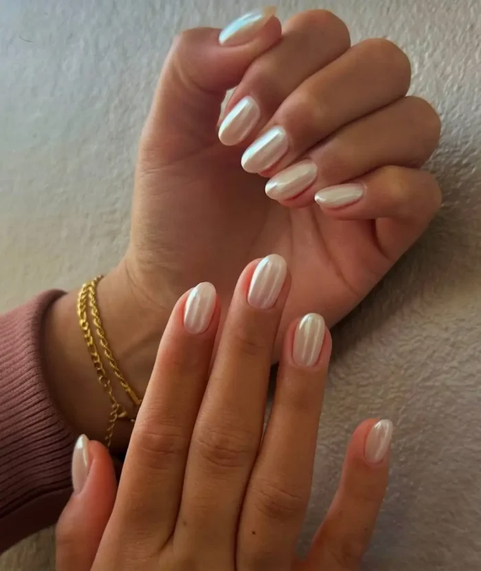 Cute simple gel manicure with a brilliant pearlescent white mother-of-pearl shimmer on medium oval almond nails.
