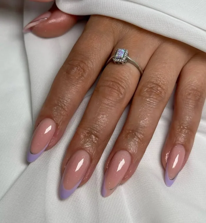 Elegant almond-shaped nails with a soft lavender French tip and a shimmering pink base, exquisitely defined by a very fine silver line along the smile curve.