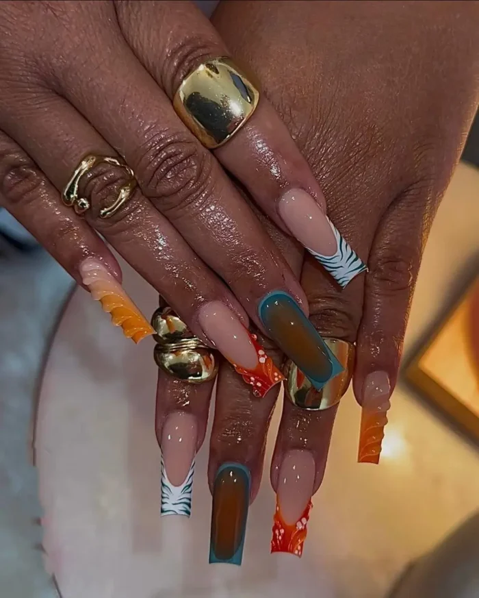 Long coffin and square nails with an eclectic summer mix of zebra print French tips, orange dots, and teal/brown tortoise shell designs.