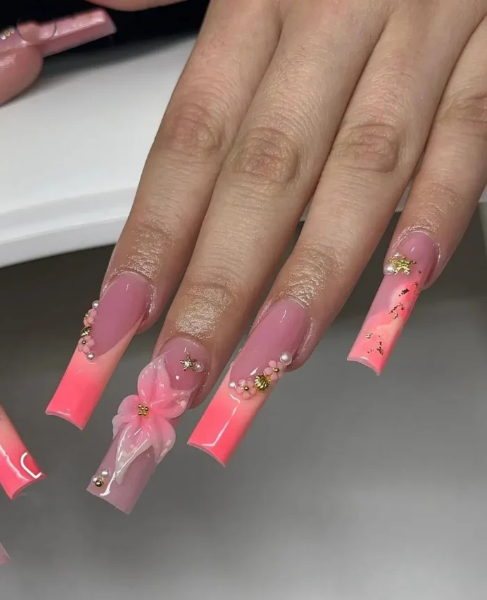 Elegant long square nails for summer: soft pink ombre French tips, delicate 3D bows, tiny pearls, and a sprinkle of gold flakes.
