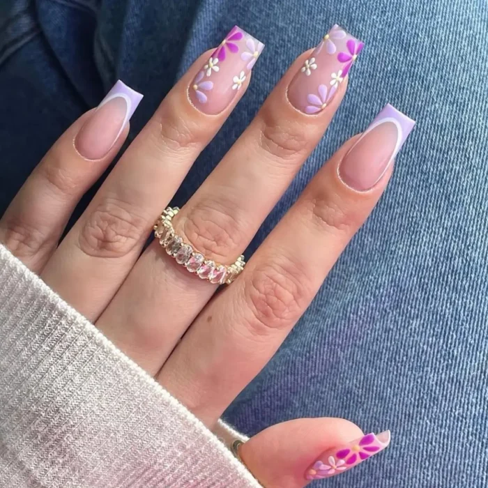 Long square nails with a lilac French bloom purple nail design, showing light purple tips and delicate floral accents.