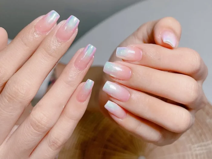 Close-up of easy pearlescent ombre nail design for beginners, featuring a soft white-to-pink fade on square nails.
