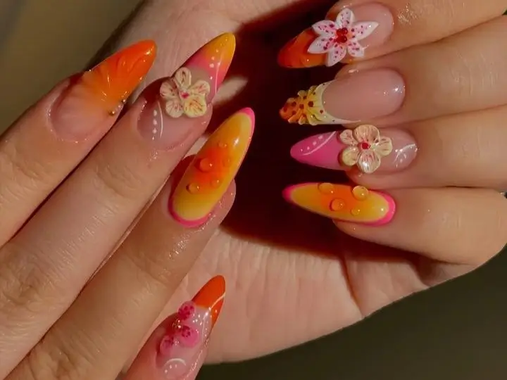 A vibrant orange-themed manicure with hand-painted oranges and white flowers, serving as nails inspo for the ultimate guide to nail art designs.
