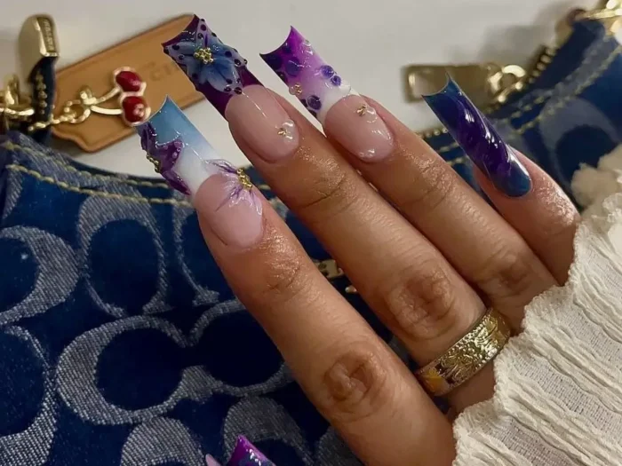 Featured image for an article showcasing 50 stunning square long nail designs: A close-up of an artistic manicure with long square nails displaying ethereal deep purple and blue abstract floral or butterfly wing patterns, accented with delicate gold studs.