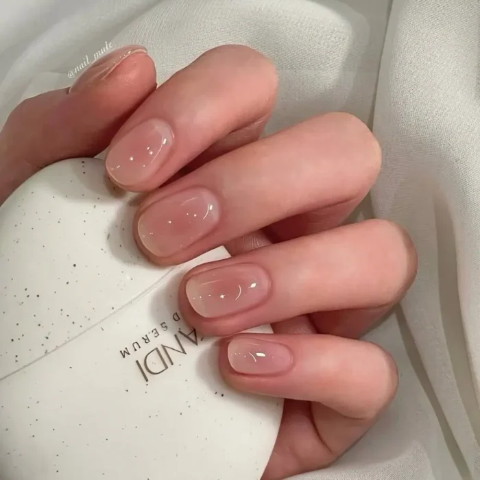Short, neatly shaped nails with a high-gloss, clear gel polish, showcasing a clean and polished natural look.