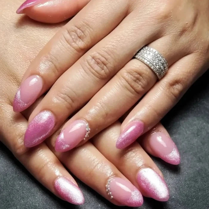 A glamorous mixed manicure on almond nails, featuring pink cat eye French tips, full glitter nails, and silver bead accents.