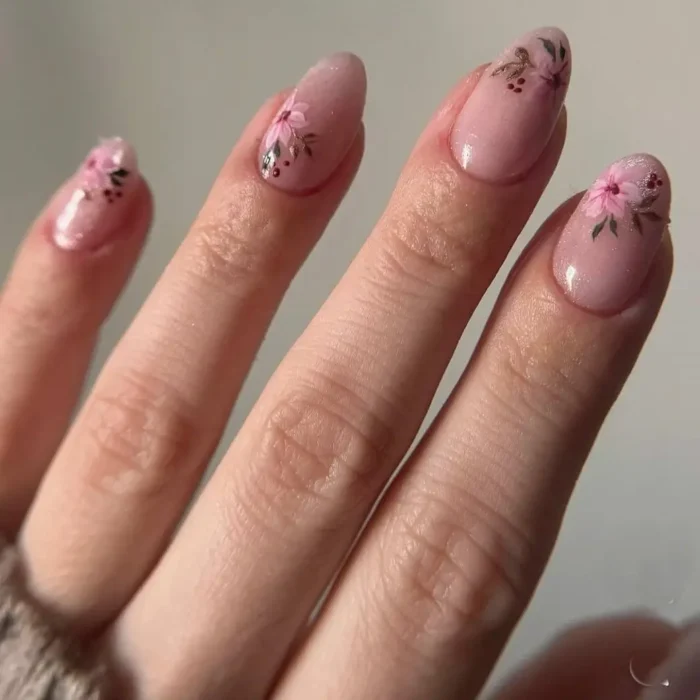 A delicate pink cat eye manicure on almond nails, featuring beautifully hand-painted pink floral art on each nail.