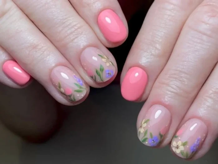 A close-up of a chic manicure showcasing flower nail art for short nails, with a mix of solid pink and delicate wildflower accent designs.