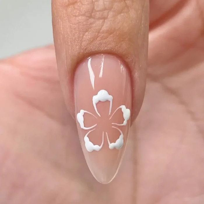 The third step of a hibiscus nail tutorial, with the soft petal shapes now refined into a clear, five-petaled white flower outline.