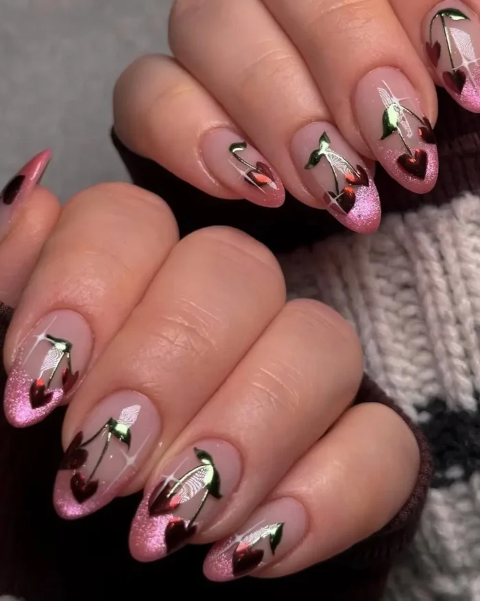 Almond nails with a pink glitter french tip and detailed red chrome cherry art.