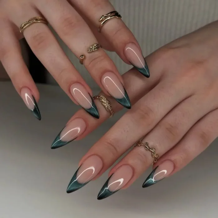 Elegant emerald green cat eye french tips on long stiletto nails.