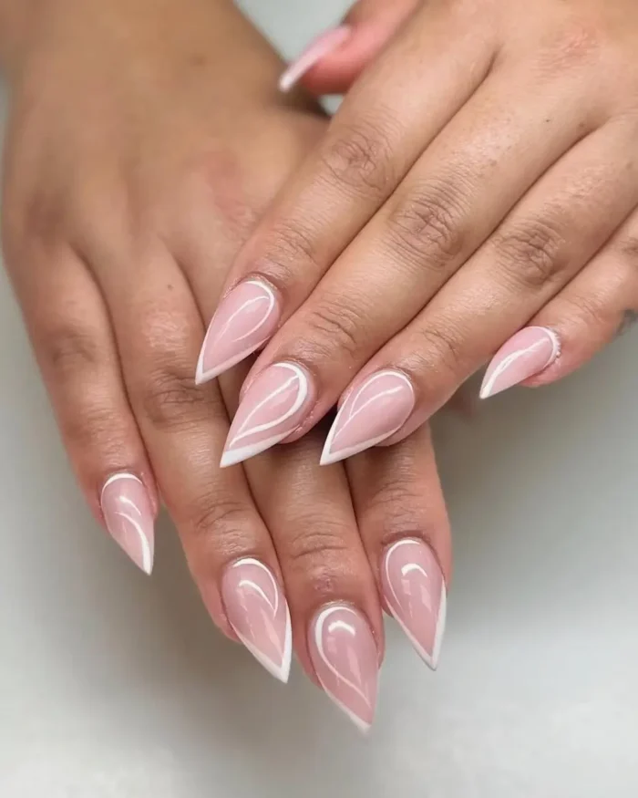 Hands showing a simple white nail art design with a sharp outline on long stiletto nails.