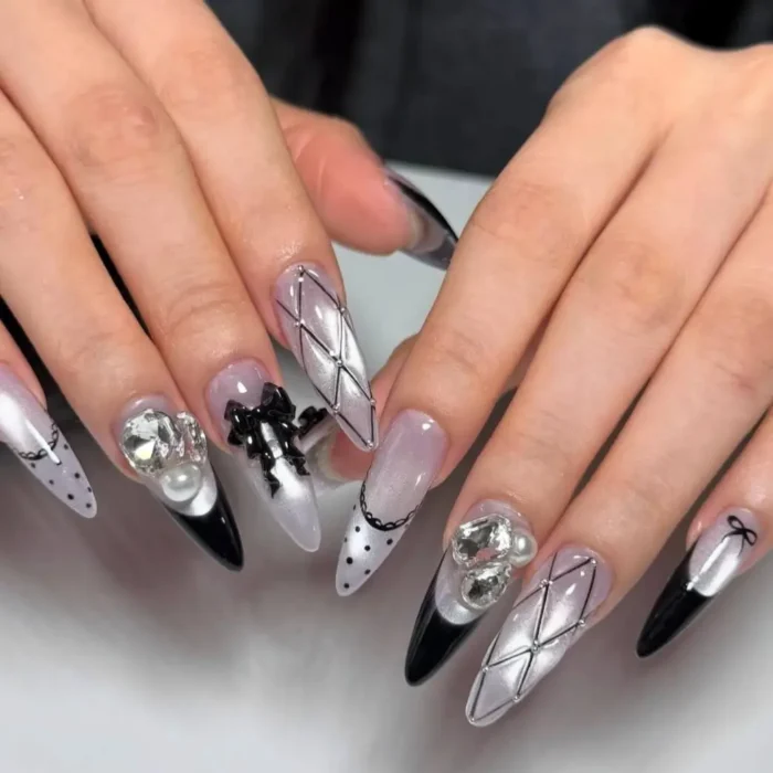 Elaborate mismatched manicure with black and white cat eye, quilted patterns, and 3D bow and crystal accents.