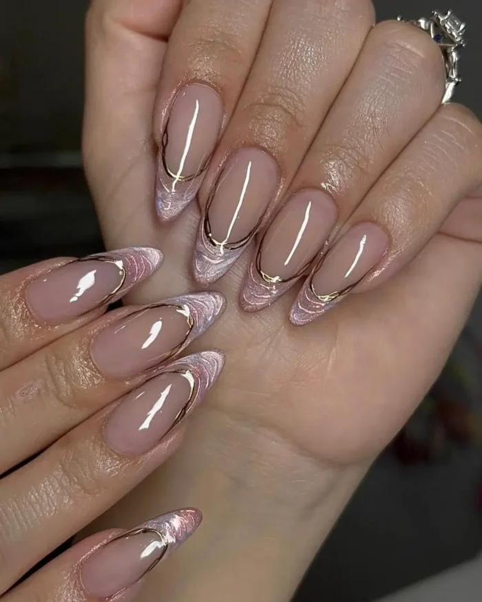 Almond nails with a marbled rose quartz french tip and a floating gold outline.