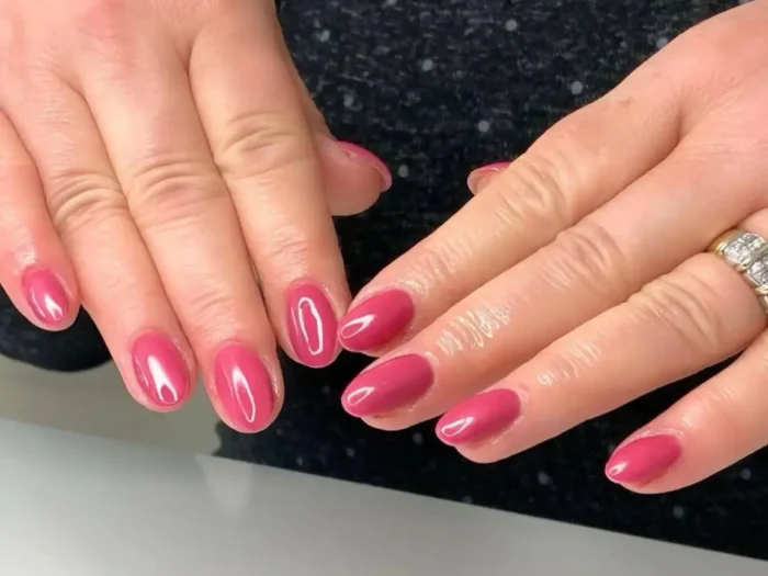 A set of hands with a simple and elegant mauve-pink manicure on short oval nails.